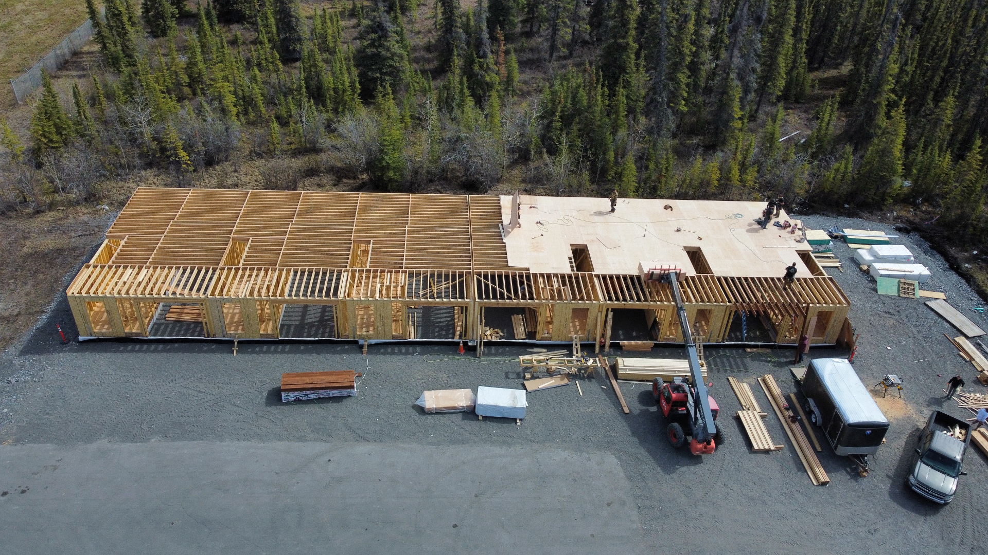 Aerial view of a large commercial wood-framing project with floor systems and crew