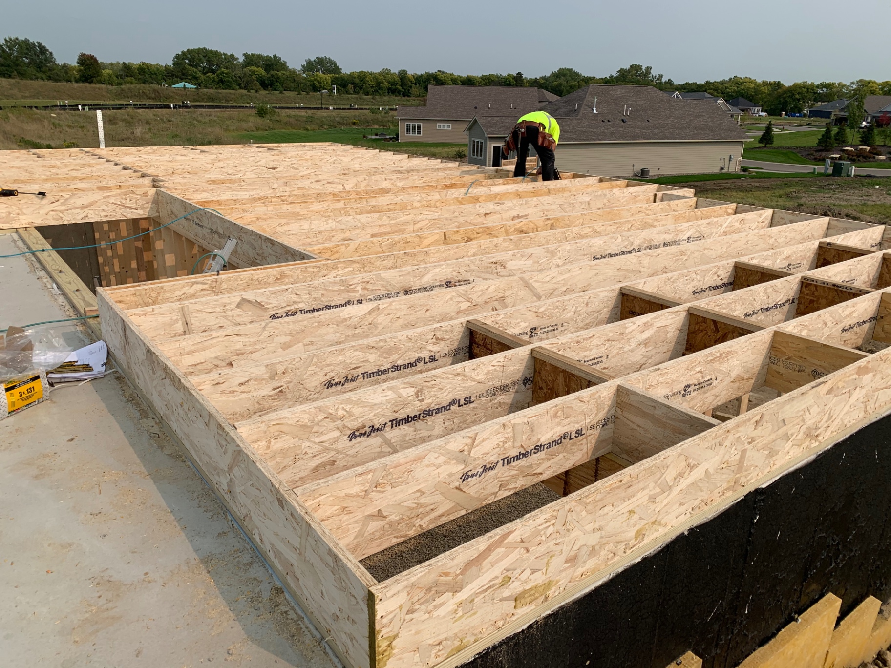 Engineered floor joists and sheathing set over a foundation
