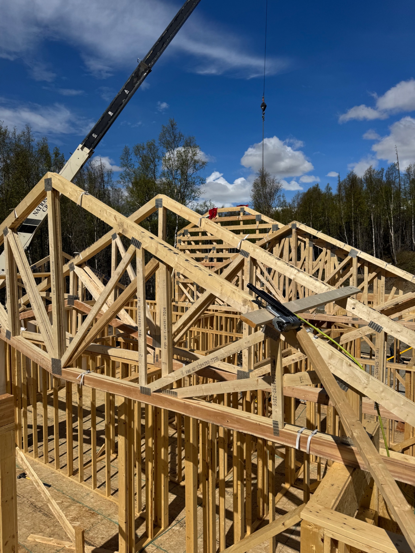 Timber roof trusses being lifted into place by a crane