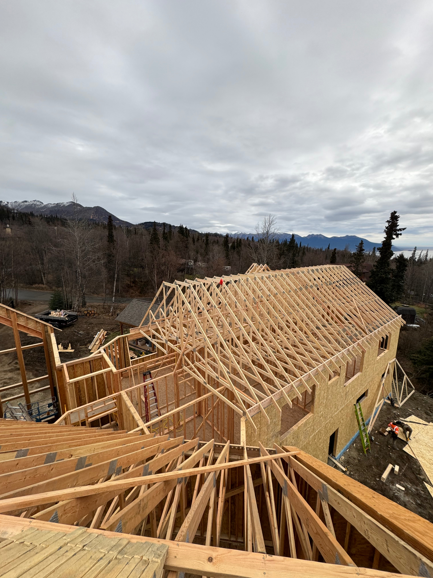Roof trusses set on a large home overlooking mountains and inlet