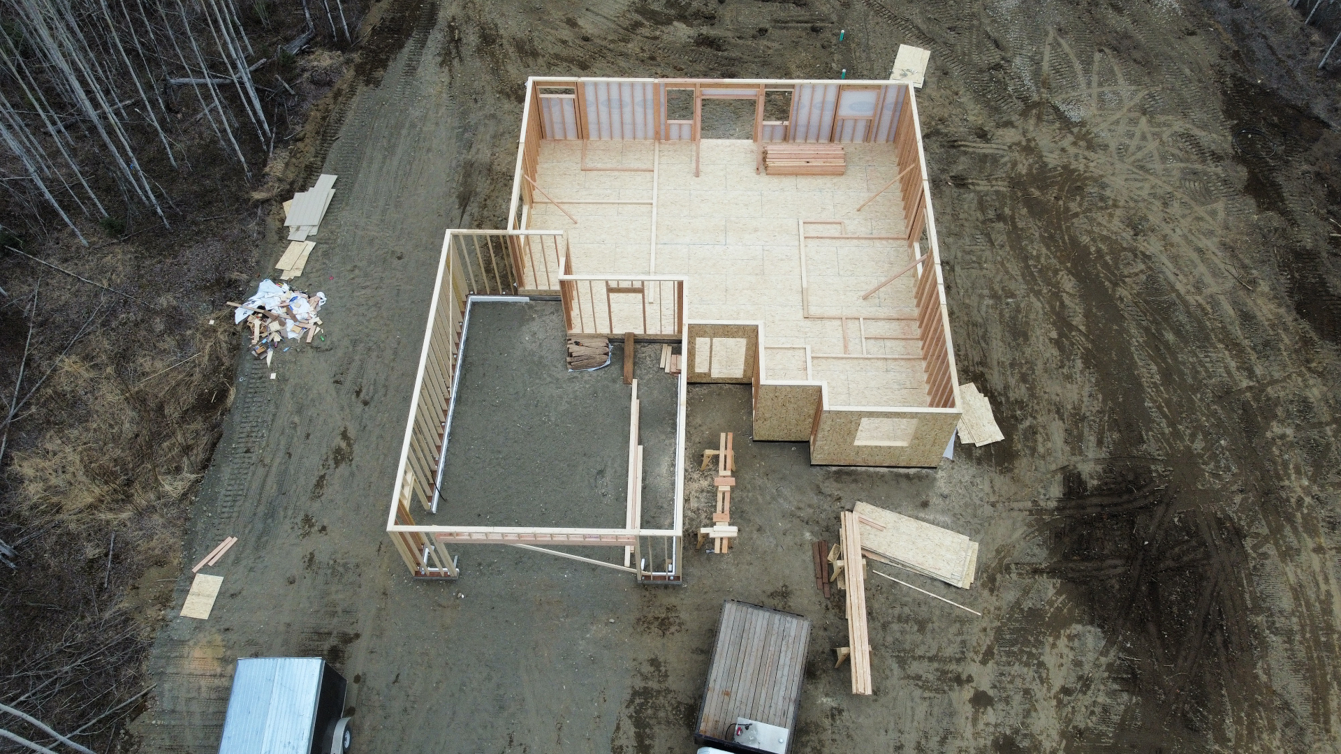Overhead drone view of a framed floor deck and wall layout on a new home site